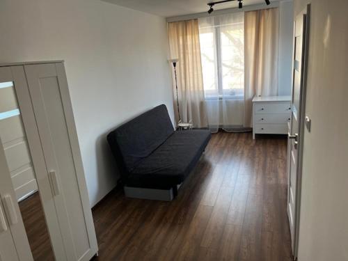 a living room with a black couch and a window at City Center Szczytno III in Szczytno