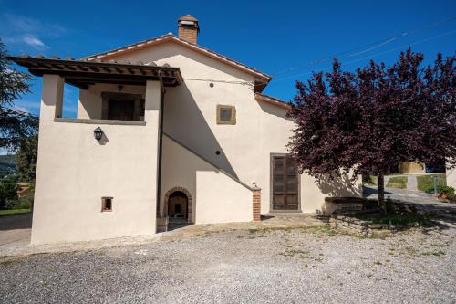 a large white house with a tree in front of it at Il Pozzo degli Angeli in Cortona