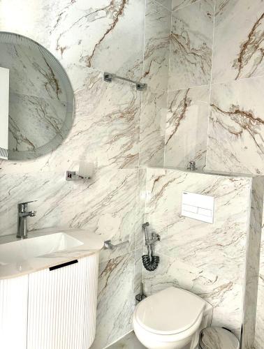 a bathroom with a toilet and a sink and a mirror at Hotel Iliria in Golem