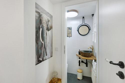 a bathroom with a painting of an elephant on the wall at Ferienwohnung Dornröschen in Olpe