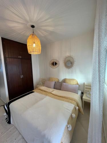 a bedroom with two beds and a chandelier at Cozy Beachfront 2BR in Rabat - Central & Secure in Rabat