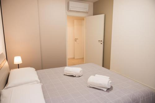 a bedroom with a bed with two towels on it at Diamante Luxury Apartment in Torri del Benaco
