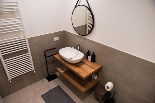 a bathroom with a white sink and a mirror at Diamante Luxury Apartment in Torri del Benaco
