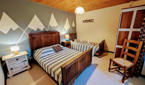 a bedroom with two twin beds and a chair at La forge in Saint-Julien-le-Petit
