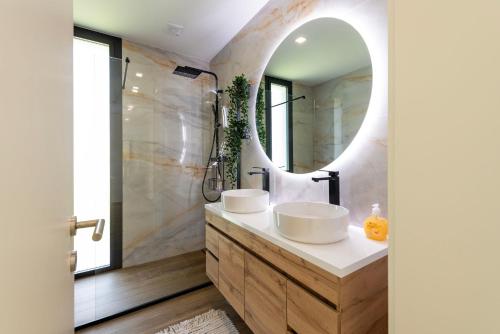 a bathroom with two sinks and a mirror at Casinha da Ribeira in Vila Verde