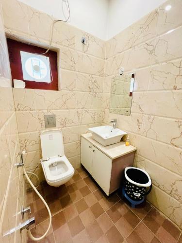 ein Badezimmer mit weißer Toilette und Waschbecken in der Unterkunft MBH hotel in Tatārsar
