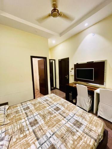 ein Schlafzimmer mit Bett und Flachbildfernseher in der Unterkunft MBH hotel in Tatārsar