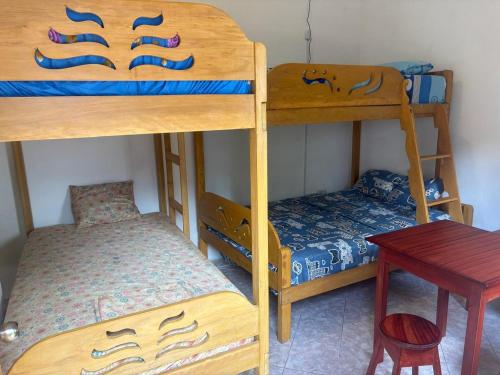 a room with two bunk beds and a table at La Lagartija Iquitos in Iquitos