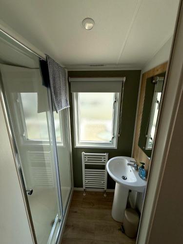 a small bathroom with a sink and a shower at Saltwinds - Camber Sands in Camber