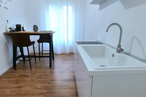 a kitchen with a sink and a table with chairs at La Casa Della Zia Scicli in Scicli