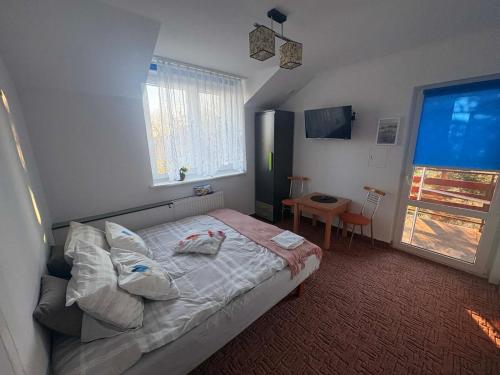 a bedroom with a bed and a window at Zaciszny domek in Słupsk