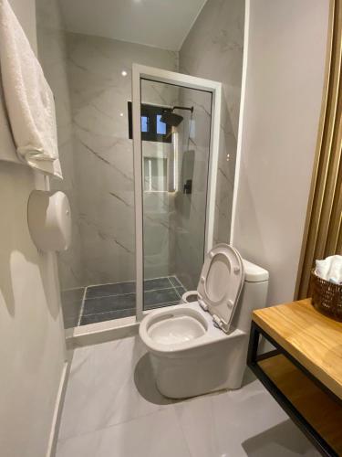 a white bathroom with a toilet and a shower at Hotel Merendón Express in San Pedro Sula