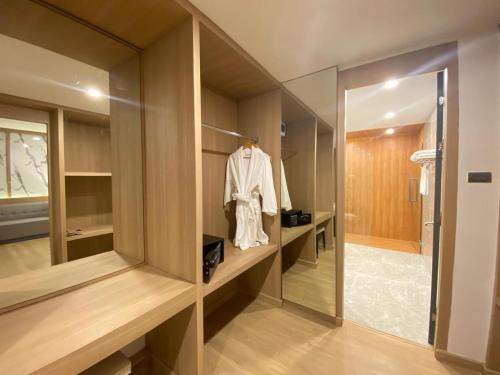 a dressing room with a mirror and a robe at ST Central Hotel, Pakse in Pakse
