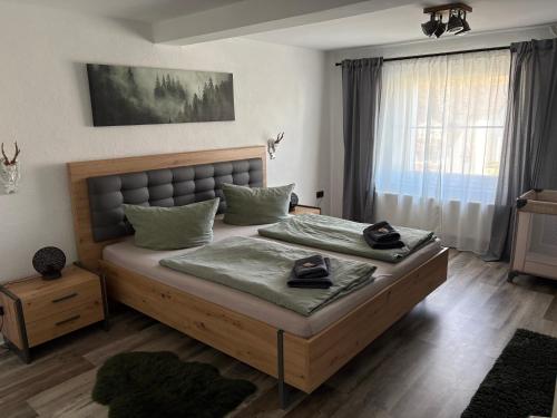 a bedroom with a large bed and a window at LandHaus Hof Wehlenbach in Hallenberg