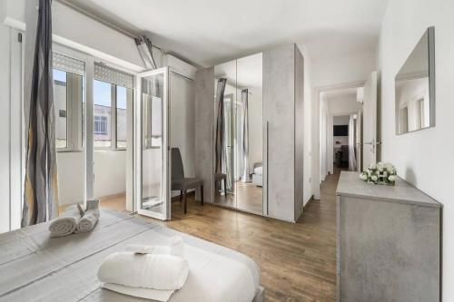 a large white room with a bed and mirrors at Mare e Relax in Quartucciu