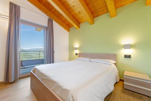 a bedroom with a large bed and a large window at Appartamenti Suly 3 - Cir0084 in Saint Vincent