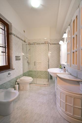 a bathroom with two sinks and a shower and a toilet at Casa Rita in Gonnosfanàdiga