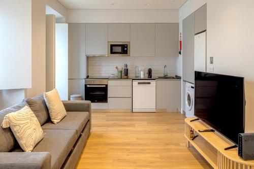 a living room with a couch and a kitchen at CapeTown Marula 1BR apartment in Caparica
