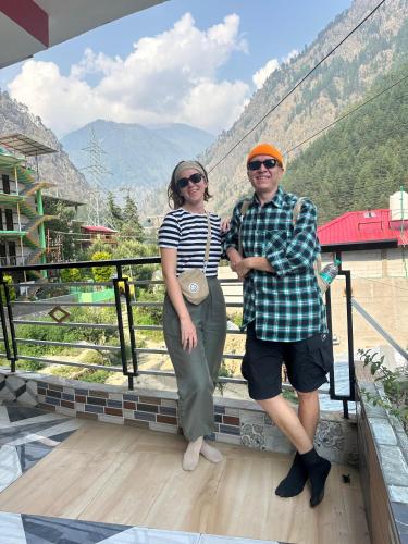 a man and a woman standing on a balcony at House of Brahma Kasol in Kasol