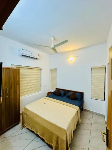 a bedroom with two beds and a ceiling fan at Castle villa in Cochin