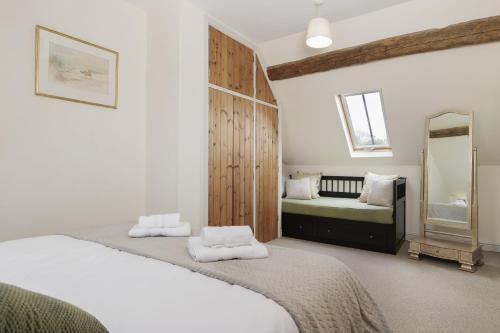 a bedroom with two beds and a mirror at Norton Subedge Barn in Mickleton
