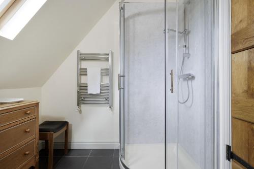 a shower with a glass door in a bathroom at Norton Subedge Barn in Mickleton