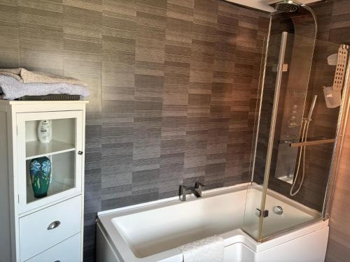 a bathroom with a shower and a white tub at Central Mablethorpe Apartment in Mablethorpe