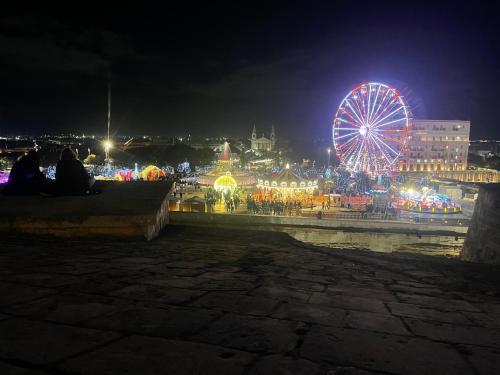 a carnival with a ferris wheel at night at MALTA TOURs in St. Paul's Bay