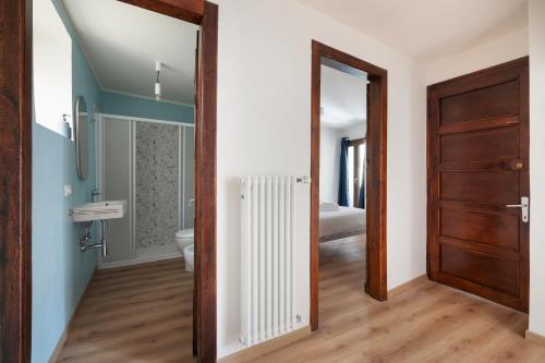 a bathroom with a toilet and a wooden door at Casa Lidia in Villaretto
