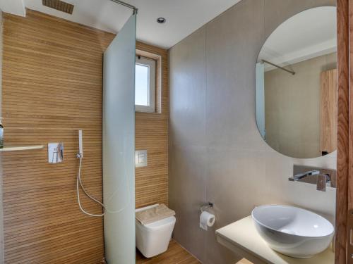 a bathroom with a sink and a toilet and a mirror at Aurelea Luxury Apartments in Kos