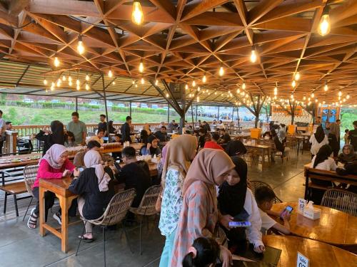 a group of people sitting at tables in a restaurant at Pandan View Mandeh Syariah in Pasarsungai-nyala