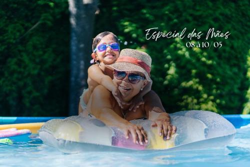 a man and a child sitting on a raft in a pool at Hotel Maui Maresias in Maresias