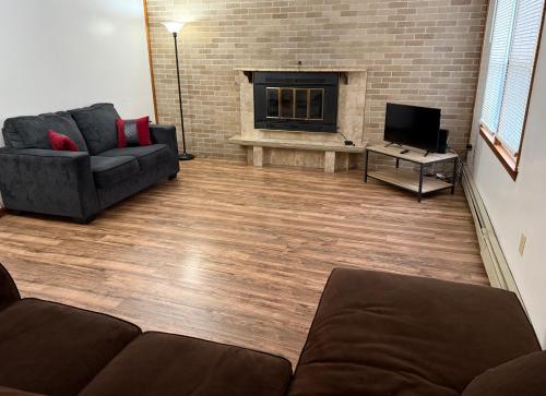 a living room with a couch and a fireplace at Private house with 4 bedrooms and 2 bathrooms, direct NYC Manhattan train only 10 minute walk away, MetLife Stadium FIFA World Cup 30 minutes away in Edison