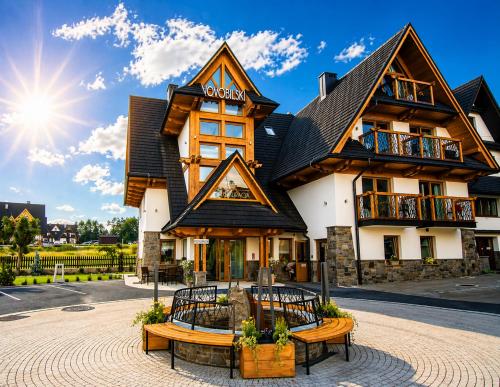 a building with benches in front of it at Novobilski przy Termie Bania i Kotelnicy - sauna, jacuzzi, restauracja, pokój zabaw, wypożyczalnia rowerów e-bike in Białka Tatrzańska