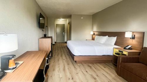 a hotel room with a bed and a couch at Studio 6 Suites Fremont, OH in Fremont