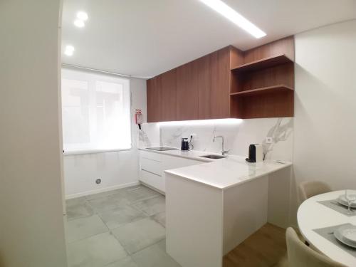 a white kitchen with a sink and a window at Da Valeta Ó in Arcos de Valdevez