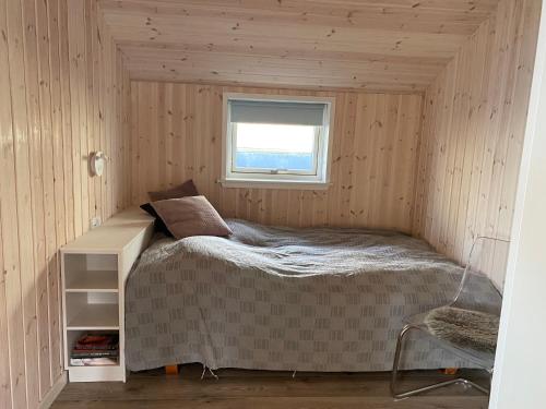 a small bedroom with a bed and a window at Udsigten over Hjarbæk in Løgstrup