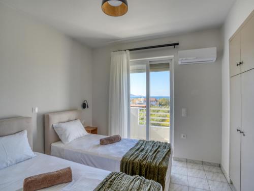 a bedroom with two beds and a balcony at Aurelea Luxury Apartments in Kos