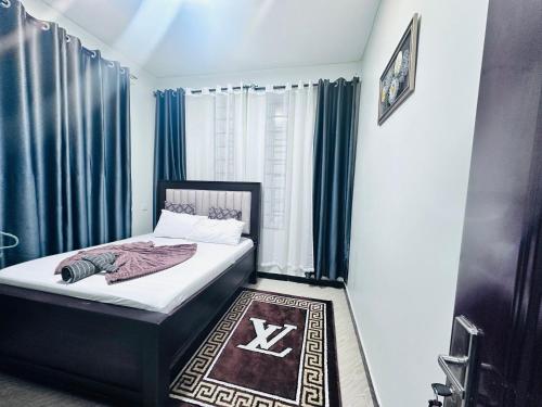 a bedroom with a bed with blue curtains and a rug at Sinza Hiddenout in Dar es Salaam