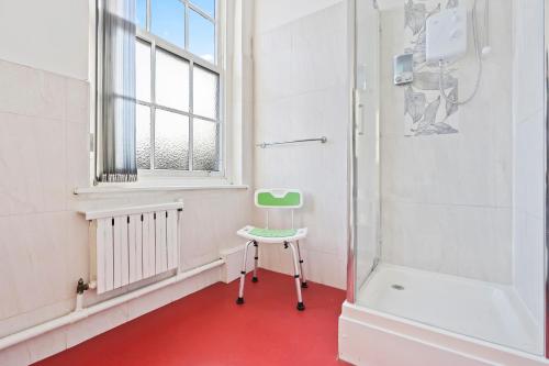 a bathroom with a green chair and a shower at Modern Self-Contained Studio in Dudley Sleeps 2 in Dudley