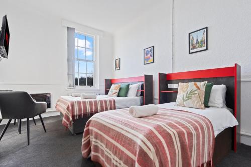 a hotel room with two beds and a chair at Modern Self-Contained Studio in Dudley Sleeps 2 in Dudley