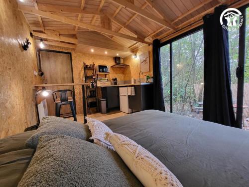 a bedroom in a tree house with a large window at La cachette du G in Bellebrune