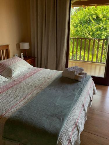 a bedroom with a bed and a large window at Casa Por Do Sol in Paraty