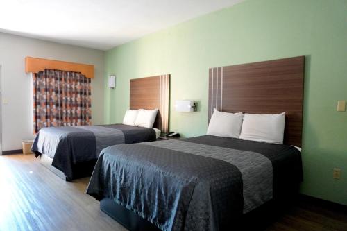 a hotel room with two beds and a window at Fairview Inn & Suites Mobile in Mobile