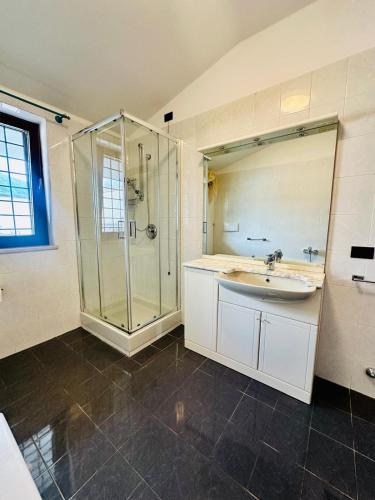 a bathroom with a glass shower and a sink at Mamisà 4 - appartamenti e camere private con bagno in Schio