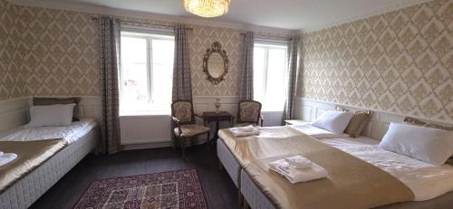 a hotel room with two beds and a mirror at Svaneholm Hotel in Svanskog