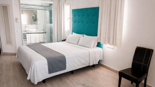 a bedroom with a large bed with a blue headboard at Hotel Clopy Rocamar in Benidorm