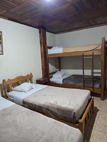 a room with two bunk beds and a chair at Hostal Las Molas in Volcán