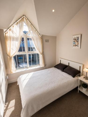 a bedroom with a large bed and a large window at Waterford Triangle Apartment in Waterford
