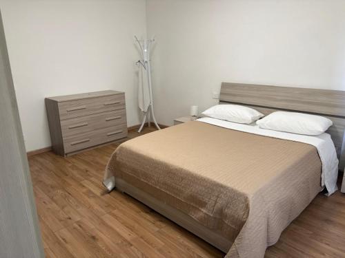 a bedroom with a bed and a dresser with a fan at Casa D'Agostino in Cortona